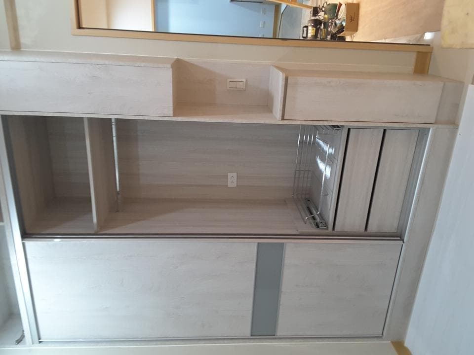 1) 照片顯示一個淺色木質衣櫃,有兩個門,門打開後露出內部架子和抽屜