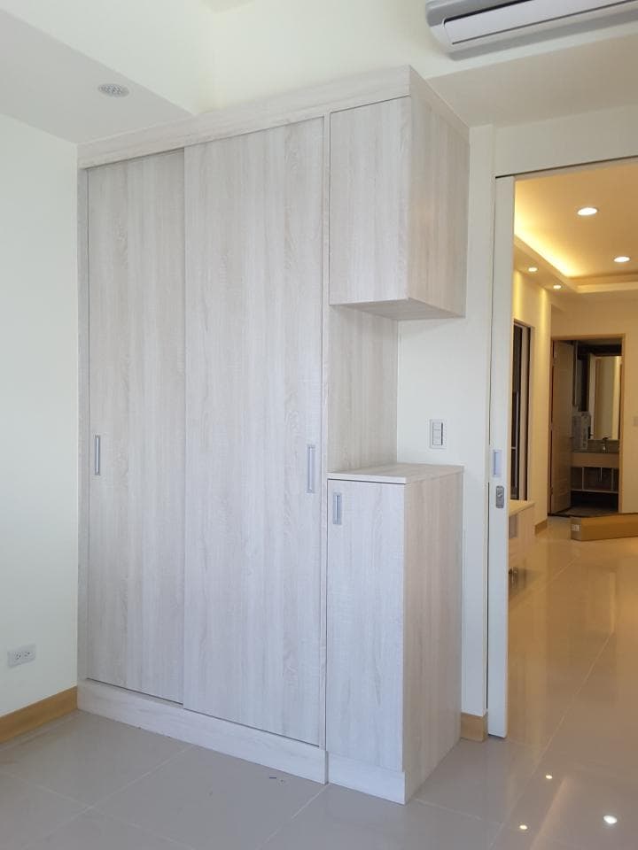 這張照片是房間裡面的白色櫃子,櫃子有三個門,上面有一個小櫃子。