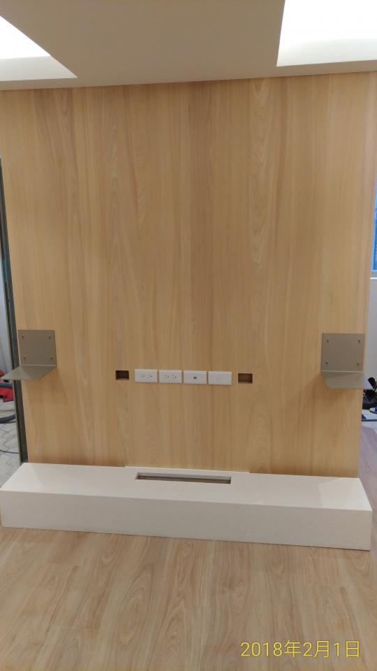 這張照片是一面牆壁,上面裝有白色的插座和兩個金屬支架,牆壁下方是一個白色平台,看起來像是一個電視櫃。