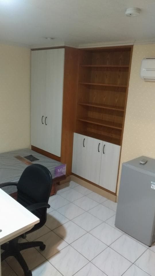 這張照片是一個房間,房間裡最重要的是一個木架,木架上有五層,層層都放滿了物品。