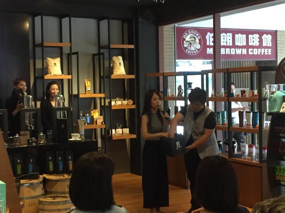 這張照片是四個人在一家咖啡館裡,其中兩個人正在櫃檯前交談。