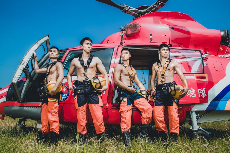 這張照片是四位消防員站在一架紅色直升機旁,他們穿著制服,表情堅定,顯露出他們對工作的熱情和對生命的尊重。