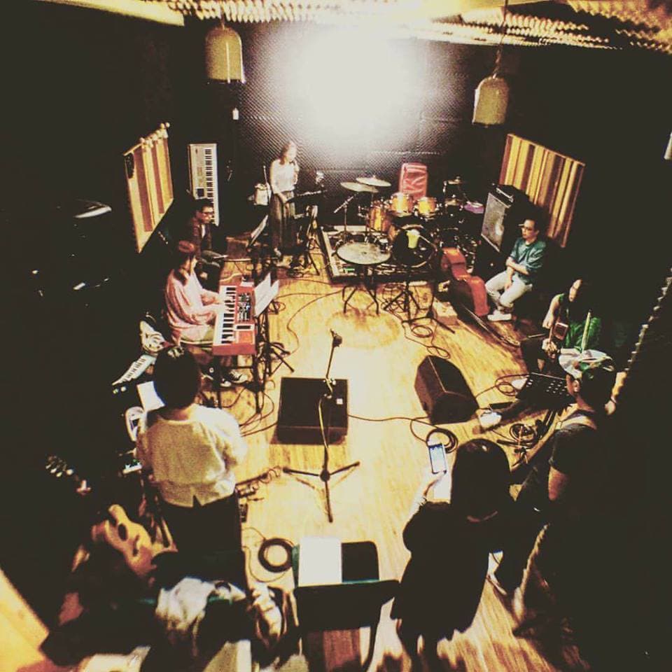 這張「樂團在排練室練習」的照片是一個樂團在排練室練習的場景,其中有四名樂手正在演奏樂器,他們演奏的樂器包括鍵盤、吉他、貝斯和鼓。