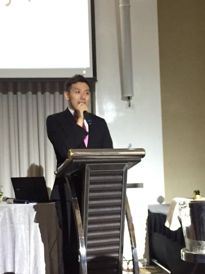 這張「一位男士在講臺上發表演講」的照片是,一位男士身穿西裝,站在講臺上,手持麥克風,正在發表演講。