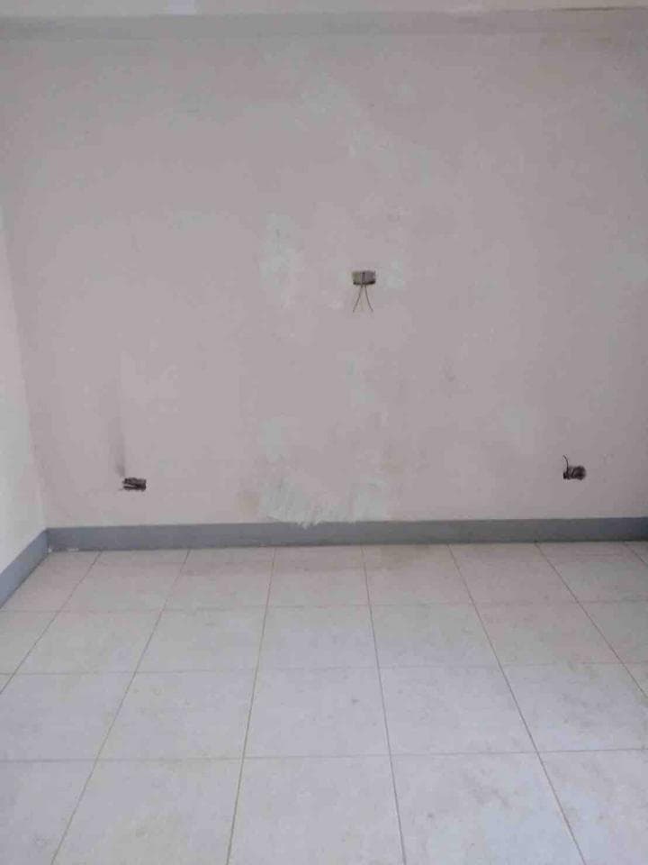 這張照片是一間尚未裝潢完成的房間,地板是白色的磁磚,牆壁刷了白色的油漆,看起來很乾淨。