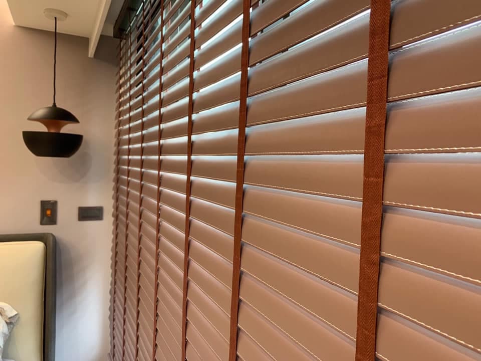 1) 照片顯示了房間裡的一扇木百葉窗,窗簾是閉合的,可以透過百葉窗看到光線