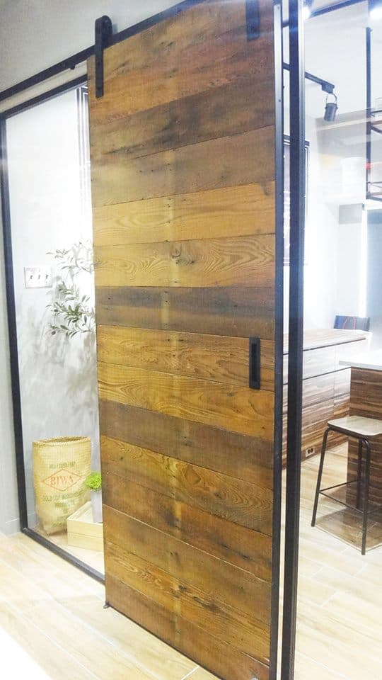 這張「木頭門」的照片是一個由多片木板組成的推拉門,門上有一個黑色的門把。