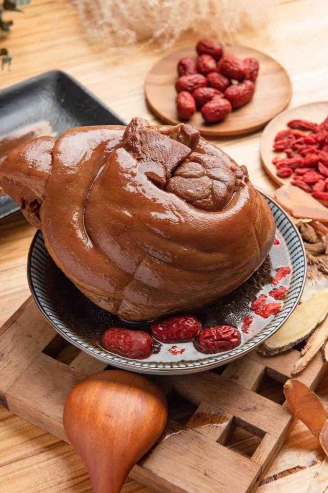 這張「滷肉」的照片是一塊色澤誘人的滷豬腳,放在一個黑色盤子上,盤子裡還有紅棗和枸杞,看起來非常美味。