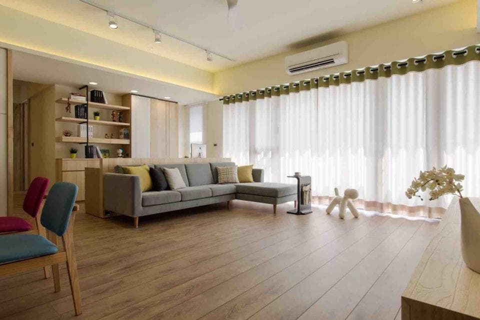 1) 照片顯示一個現代客廳,配有灰色沙發、木地板、白色窗簾和綠色窗簾