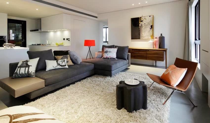 這張「客廳」的照片是一間現代化的客廳,裡面有灰色沙發、紅色落地燈、木頭櫃子和一張皮製單人椅。