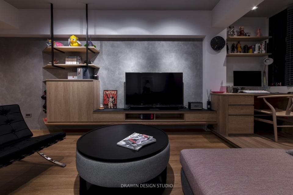 這張「客廳」的照片是一個現代化的客廳,裡面有一個大電視、一張黑色沙發和一張木桌。