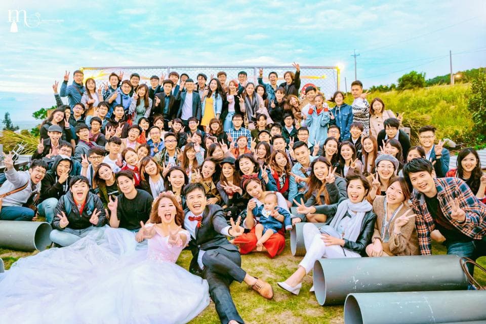這張「婚禮」的照片是新人和他們的親朋好友在戶外舉辦婚禮,眾人開心合影留念。