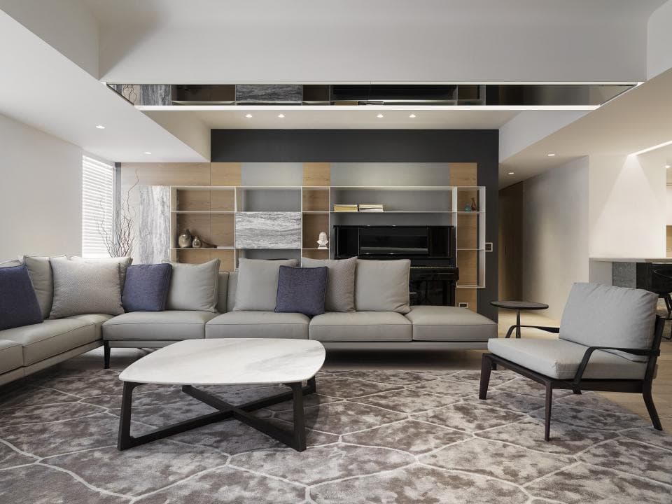 這張「現代化客廳」的照片是一間寬敞的客廳,擺放著一張大型的沙發、一張方形的茶几,以及一張單人沙發。客廳裡還有大型的書架和電視櫃。