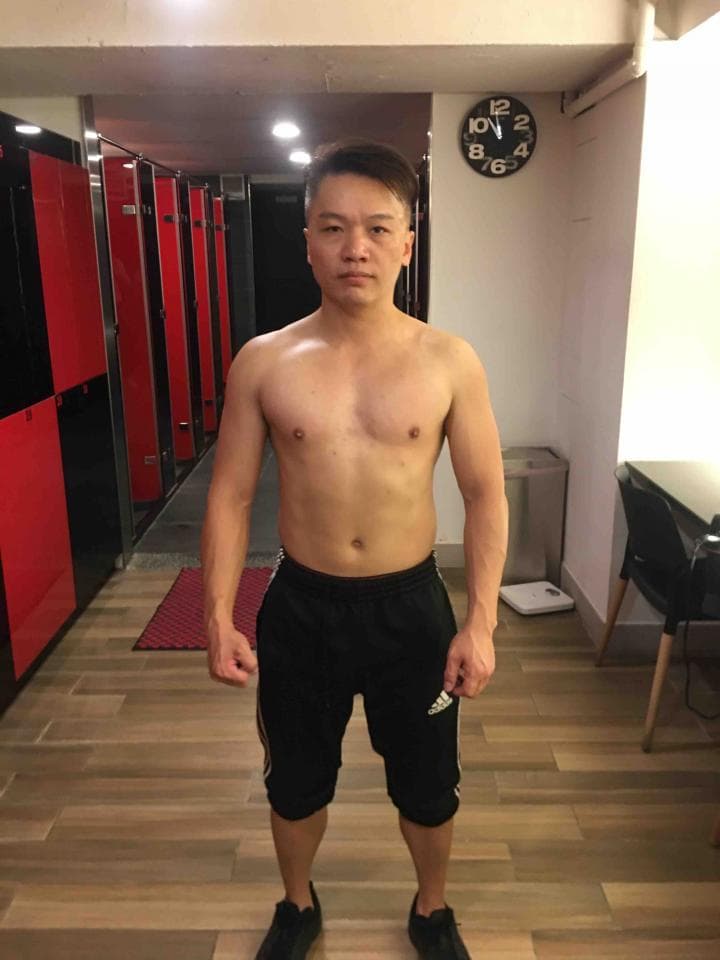 這張「健身房更衣室」的照片是一個穿著黑色運動短褲的男人,他正在鏡子前擺姿勢。