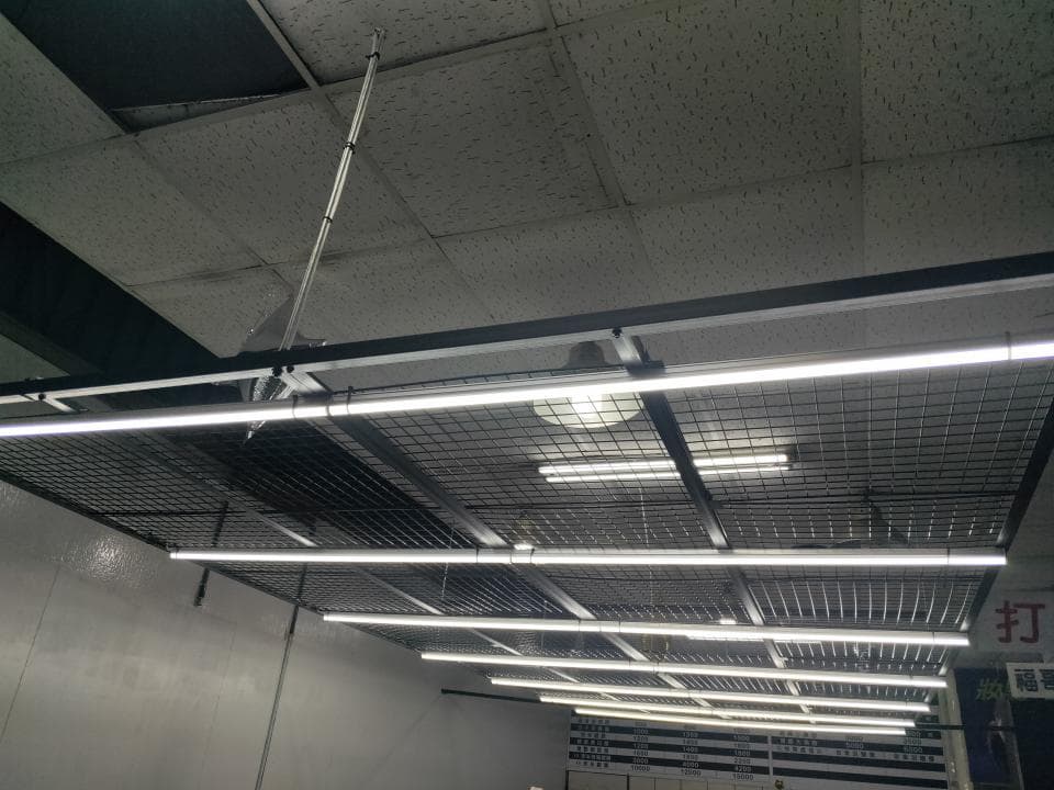 這張照片是一間商店的天花板,天花板上裝有網狀格柵和多盞明亮的LED燈,為商店提供充足的照明。