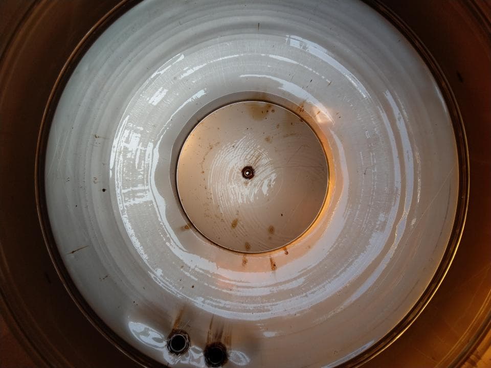 這張照片是一個金屬容器的內部,最重要的是中心的一個圓形孔,它看起來像一個蓋子,周圍有許多同心圓,可能用於儲存或運輸液體。