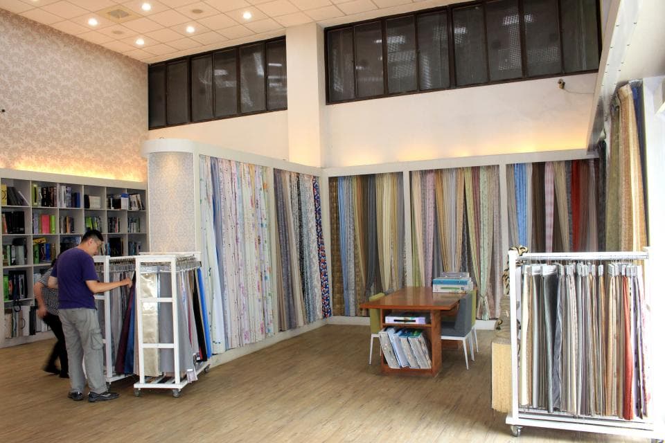 1) 照片顯示一家窗簾店,店內有各種不同款式和顏色的窗簾布料,展示在架子上