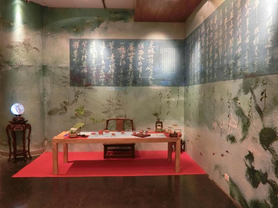 這張「禪風茶室」的照片是一間簡單樸實的茶室,牆壁上掛著字畫,桌子上擺放著茶具,茶室的佈置非常雅緻。