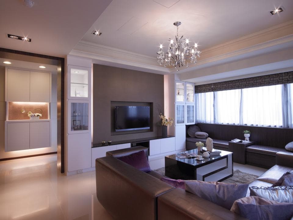 這張「現代風格客廳」的照片是一個舒適的空間,有著深色的牆壁、皮革沙發、電視櫃,以及一個時尚的水晶吊燈。