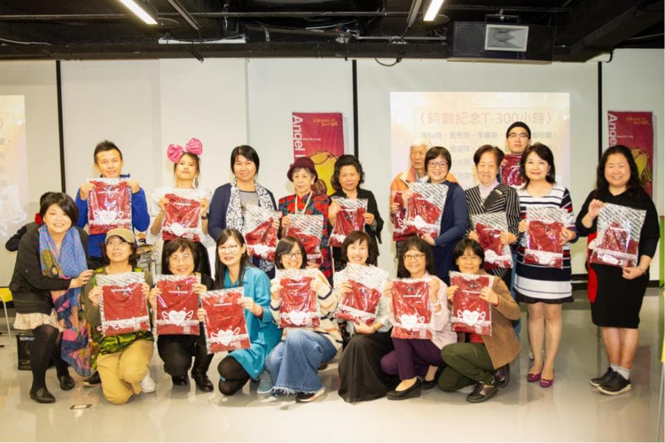 這張照片是一群人站在一起,他們都拿著紅色的禮物,看起來像是慶祝活動或聚會的場面。