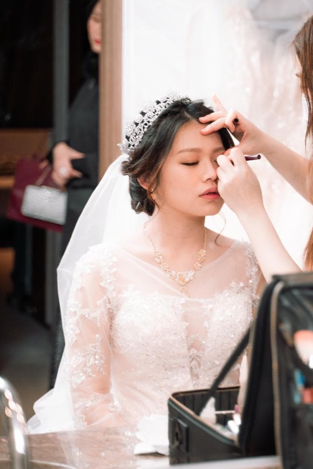 這張照片是一個穿著婚紗的新娘,正在化妝。