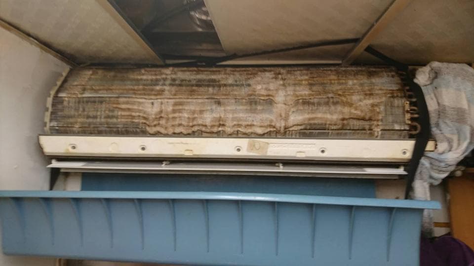 1) 這張照片顯示一個髒兮兮的空調機組,它安裝在一個房間的天花板上