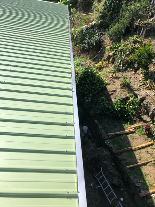 1) 照片顯示一個綠色的金屬屋頂和一個銀色的雨水槽