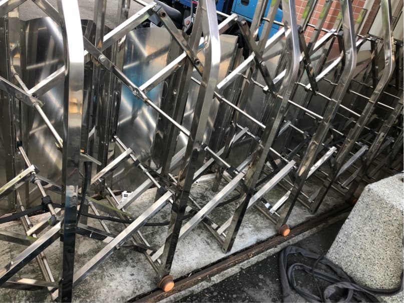 1) 照片顯示了一排金屬柵欄,看起來像是折疊式,似乎是堆放在地面上