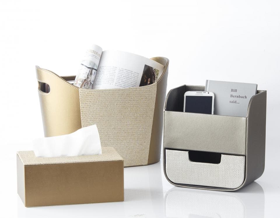 這張照片是一個時尚的儲物架,有兩個抽屜和一個金色的儲物箱,可以用來存放各種物品,例如手機、書籍和雜誌。