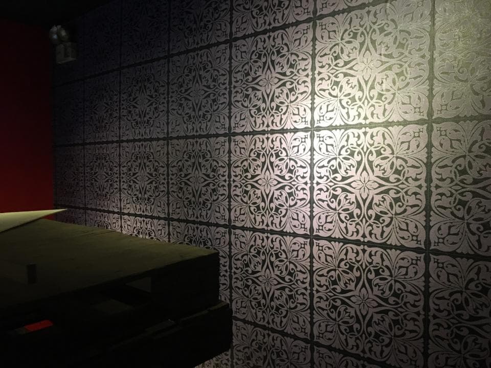 1) 照片顯示一間房子的牆壁,牆壁上貼了花紋的壁紙