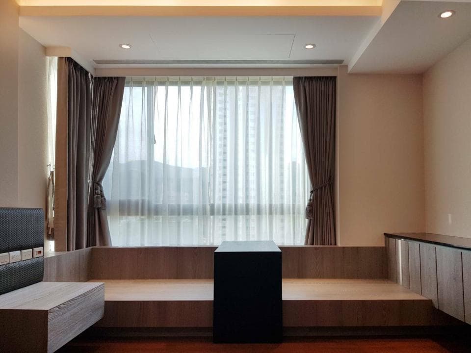 1) 這是一張室內設計的照片,照片顯示一個裝修精美的客廳,包含一個木質沙發、一張黑色茶几、以及窗戶,窗戶上有窗簾和紗簾