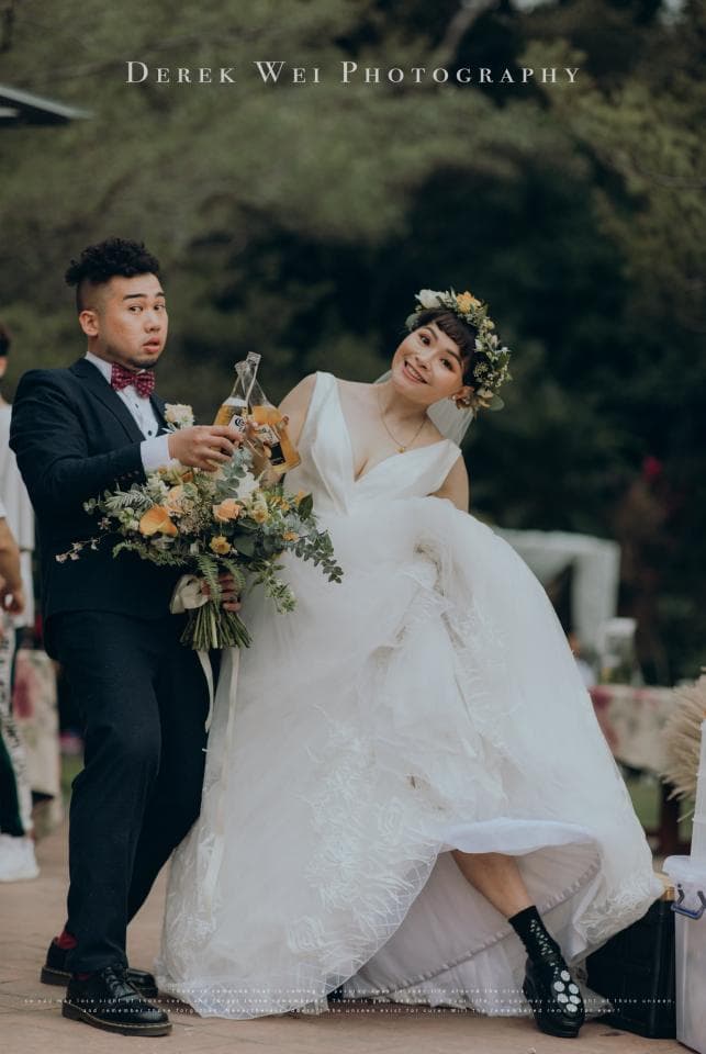 這張照片是一對新人結婚的婚禮照,最重要的是新娘穿著美麗的白色婚紗,手持捧花,笑著看著鏡頭,幸福洋溢。