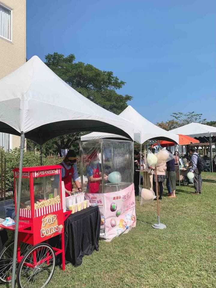 這張照片是路邊的攤位,攤位上擺著爆米花機和棉花糖機,看起來像是嘉年華會的攤位。