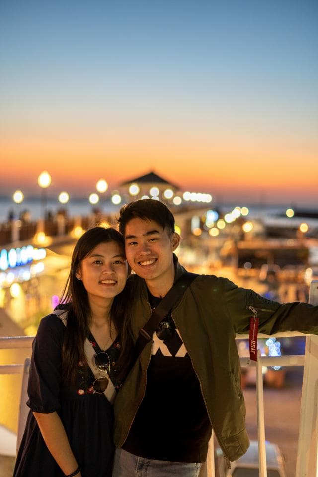 這張照片是一對年輕情侶,他們依偎在一起,面帶笑容,顯得非常甜蜜。