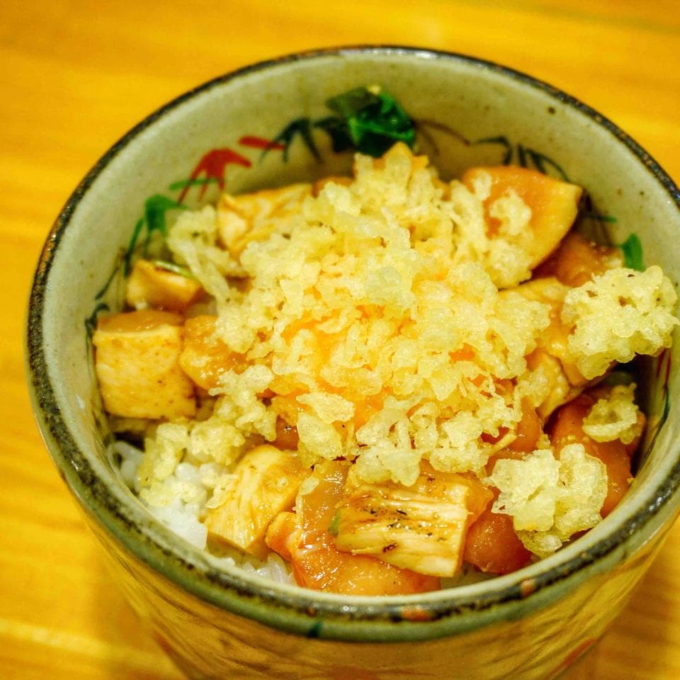 這張「丼飯」的照片是一碗日式料理,上面放了大量的炸物,配上白飯。