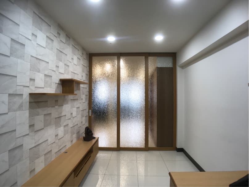 1) 照片顯示一個帶有木質壁板的現代化房間,房間的牆壁上有仿石的壁紙