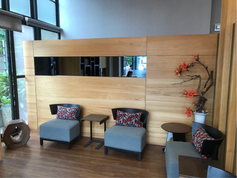 1) 照片顯示了一個現代的客廳,有木質牆壁、兩個藍色沙發、兩個咖啡桌和一個花瓶