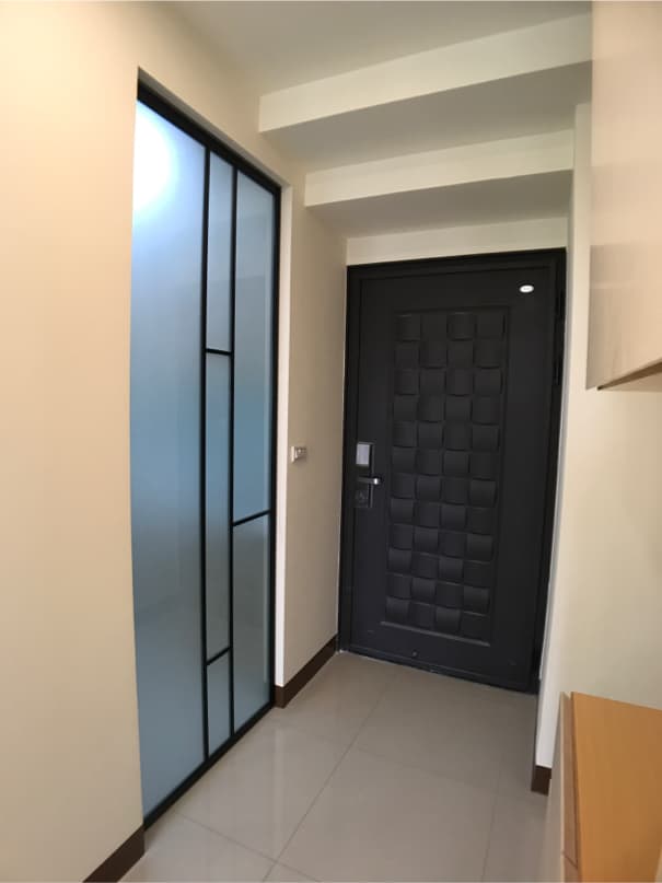 1) 照片顯示一個帶有黑色框架的玻璃門,旁邊有一扇黑色的門,兩扇門的後面都有白色牆壁