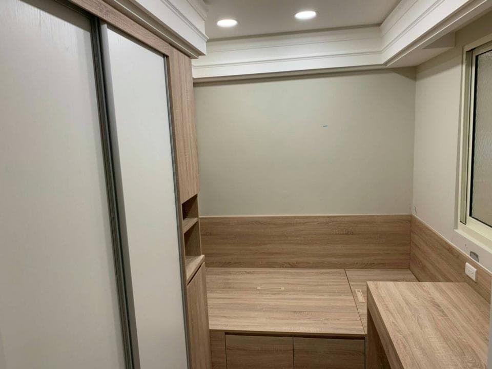 這張照片是一間臥室,照片中最重要的部分是牆壁上的白色推拉門。門的表面光滑平整,門板採用白色,帶有淡淡的木紋,與房間整體的裝修風格相得益彰。