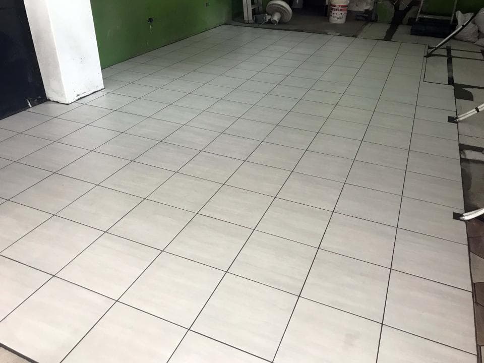 1) 照片顯示一個鋪設完成的白色瓷磚地板