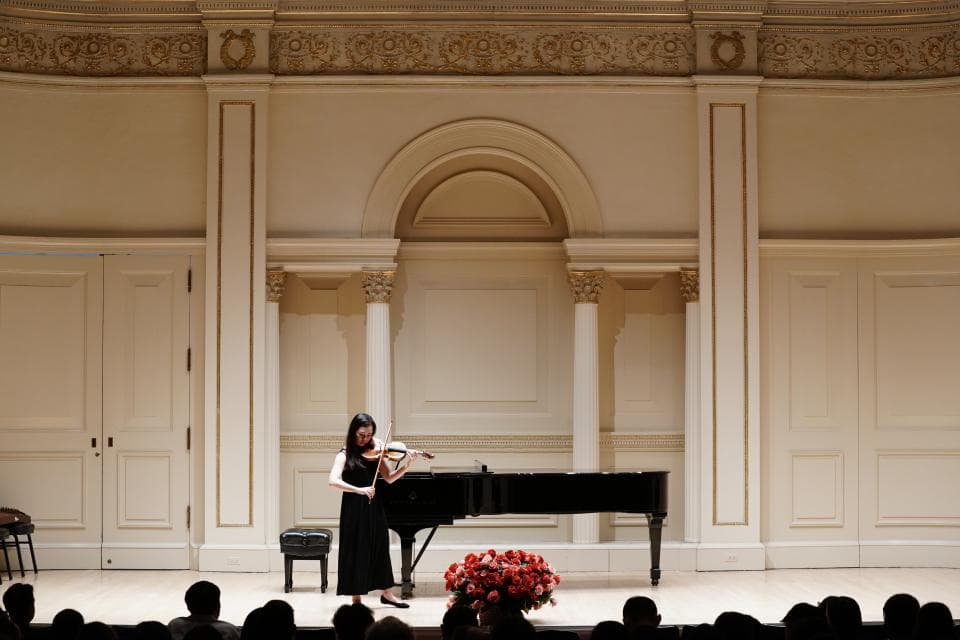 這張照片是一名女子在古典音樂廳中演奏小提琴。