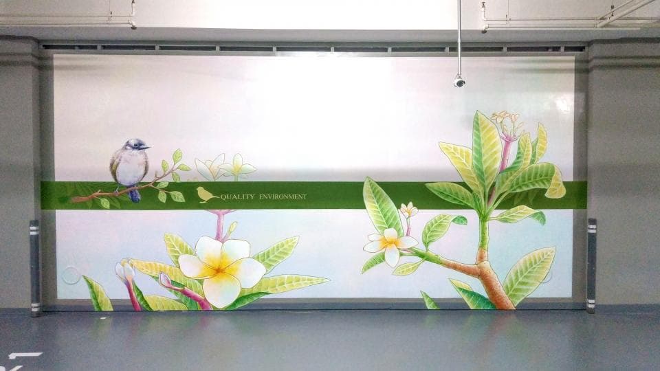 這張照片是一面牆壁上繪有花卉圖案的壁畫,畫中有一隻小鳥棲息在樹枝上,樹枝上盛開著許多白色和黃色的花朵。