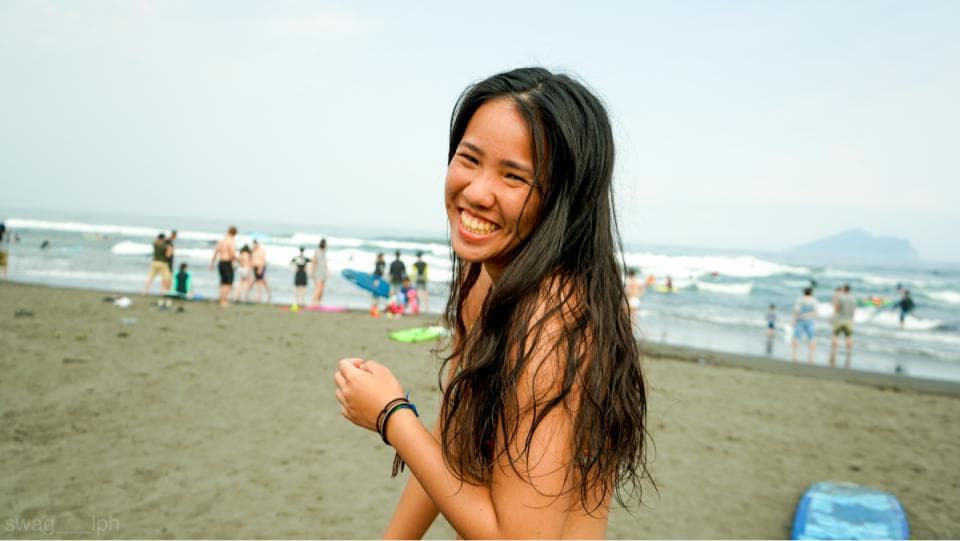 1) 照片顯示一位年輕女性站在海灘上,她穿著比基尼,面帶微笑,背景是海和沙灘