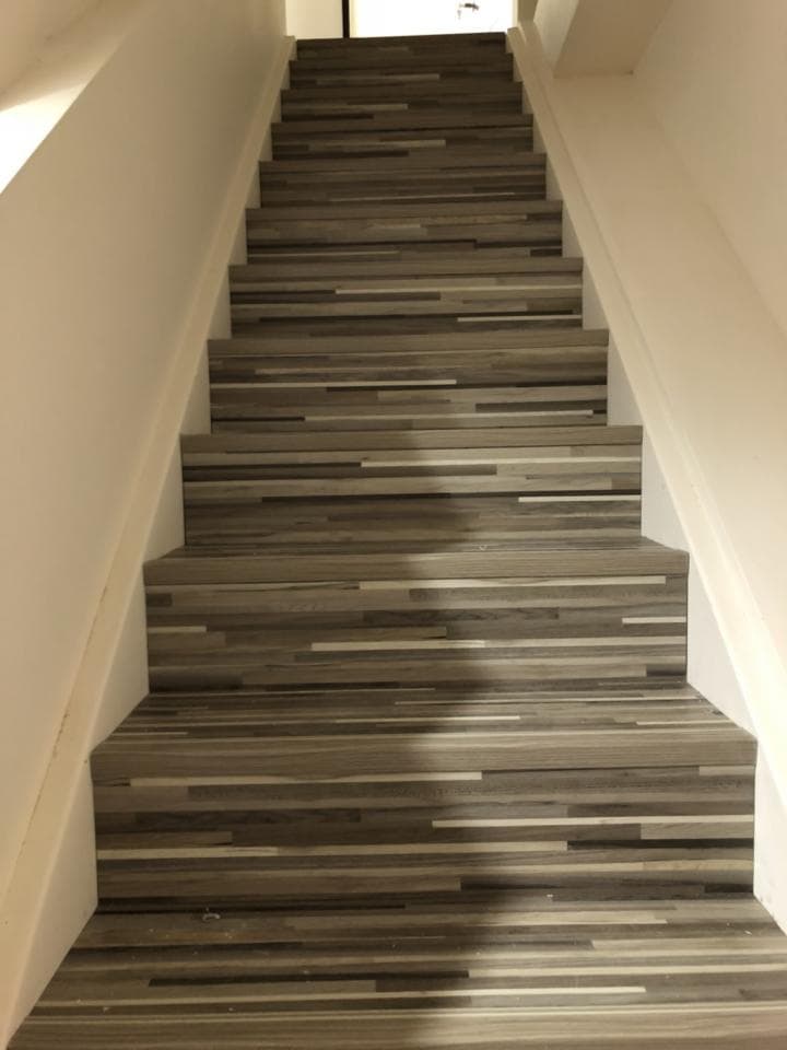 1) 這是一張照片,顯示了一段木質樓梯,樓梯上有灰白色木質地板