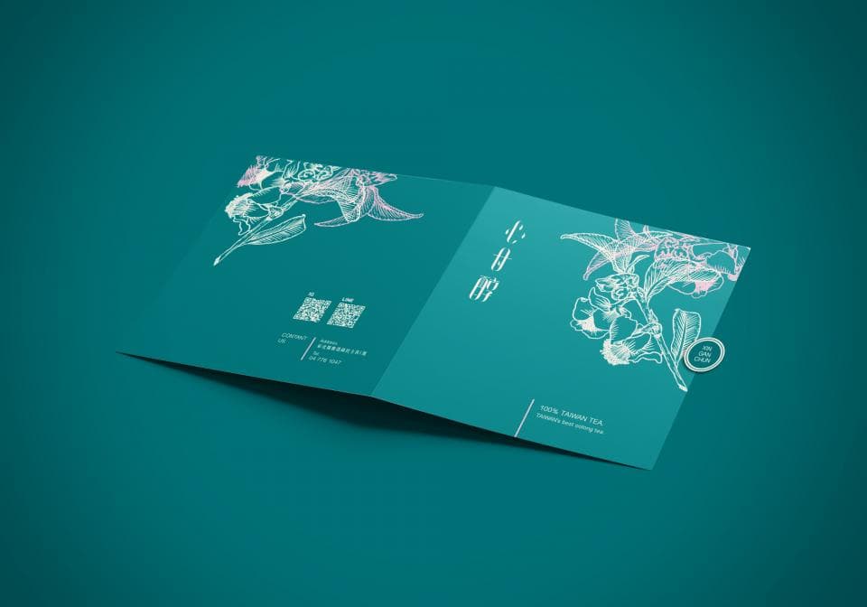 這張照片是一本綠色封面的摺疊式小冊子,上面印著白色花朵圖案,並有三三二字。