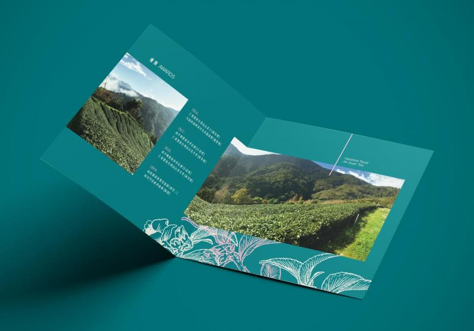 這張照片是一個關於茶葉的宣傳冊,最重要的是它展示了生長在山上的茶葉,以及精美的茶葉圖案,顯示了茶葉的高品質和自然美。