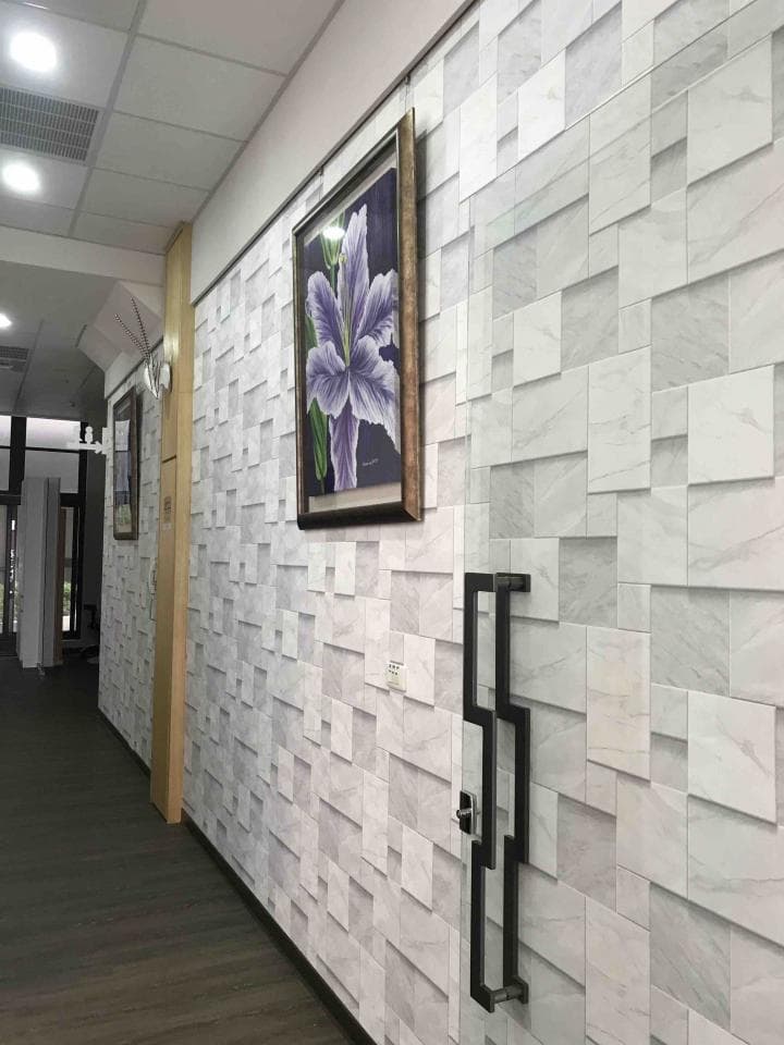 1) 照片中顯示一間裝潢精美的房屋的走廊,牆壁上鋪設了白色磚瓦,並且掛著一幅紫色花朵的油畫