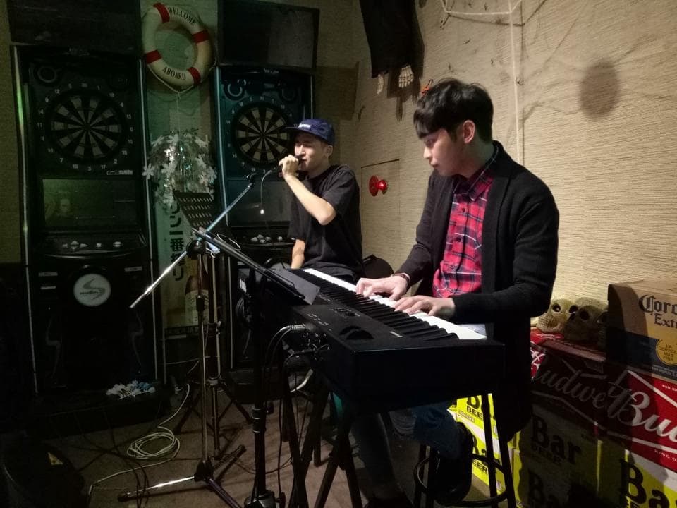 這張「酒吧」的照片是兩位男子在演奏,一位正在彈鍵盤,另一位在唱歌。