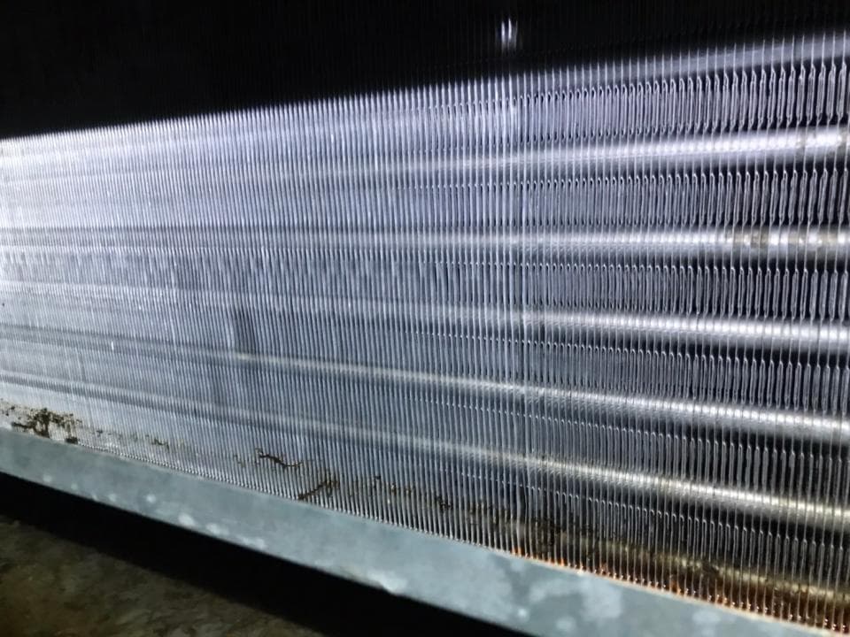 1) 照片顯示一個冷氣機的冷凝器,冷凝器上佈滿了灰塵和污垢