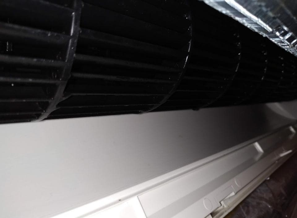 1) 照片顯示一個空調的內部,可以看到一個黑色風扇葉片,以及一個白色塑膠外殼